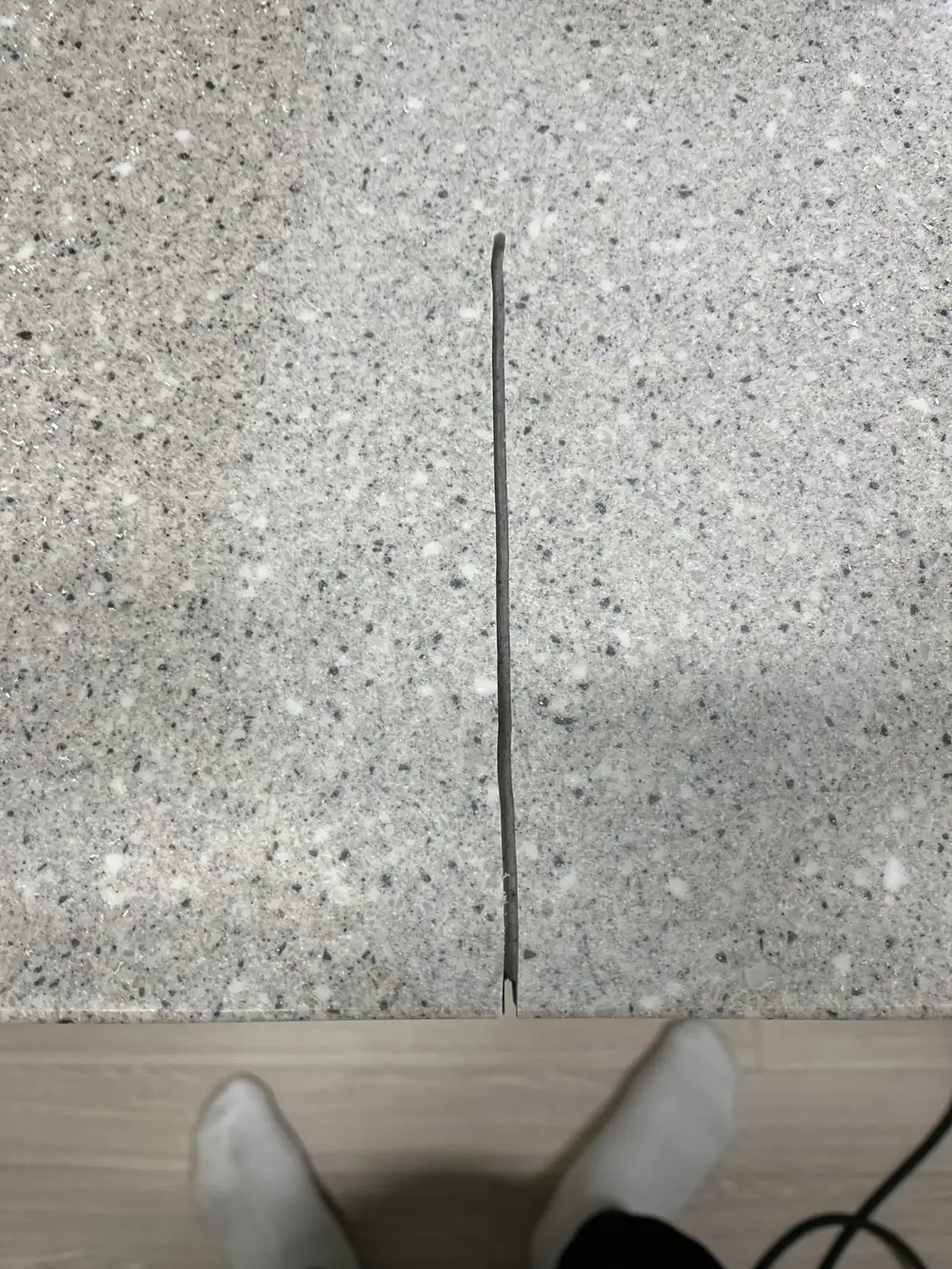 싱크대 상판 한가운데를 세로로 가로질러 앞쪽 모서리까지 이어진 균열선, 보수 이전 모습