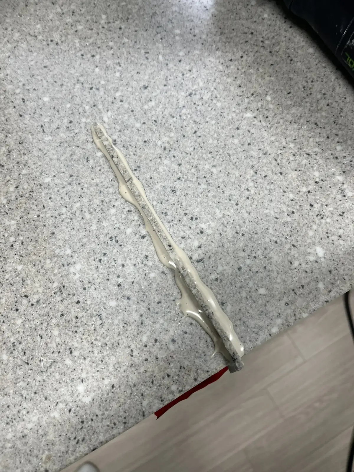 상판 위에 놓인 보강 조각 둘레로 크림색 접착 레진이 길게 번진 모습, 싱크대 상판 보수 진행 중
